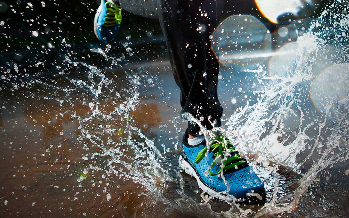 runner splashing through puddle
