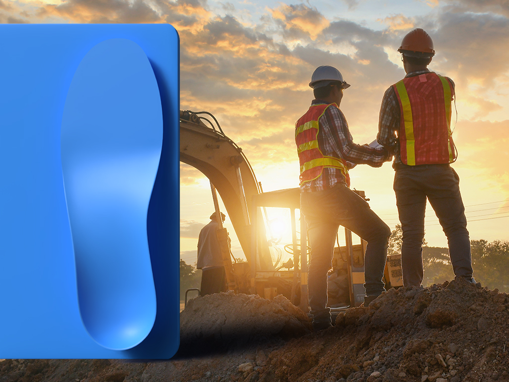 A blue poured PU insole imposed over an image of construction workers on a jobsite.