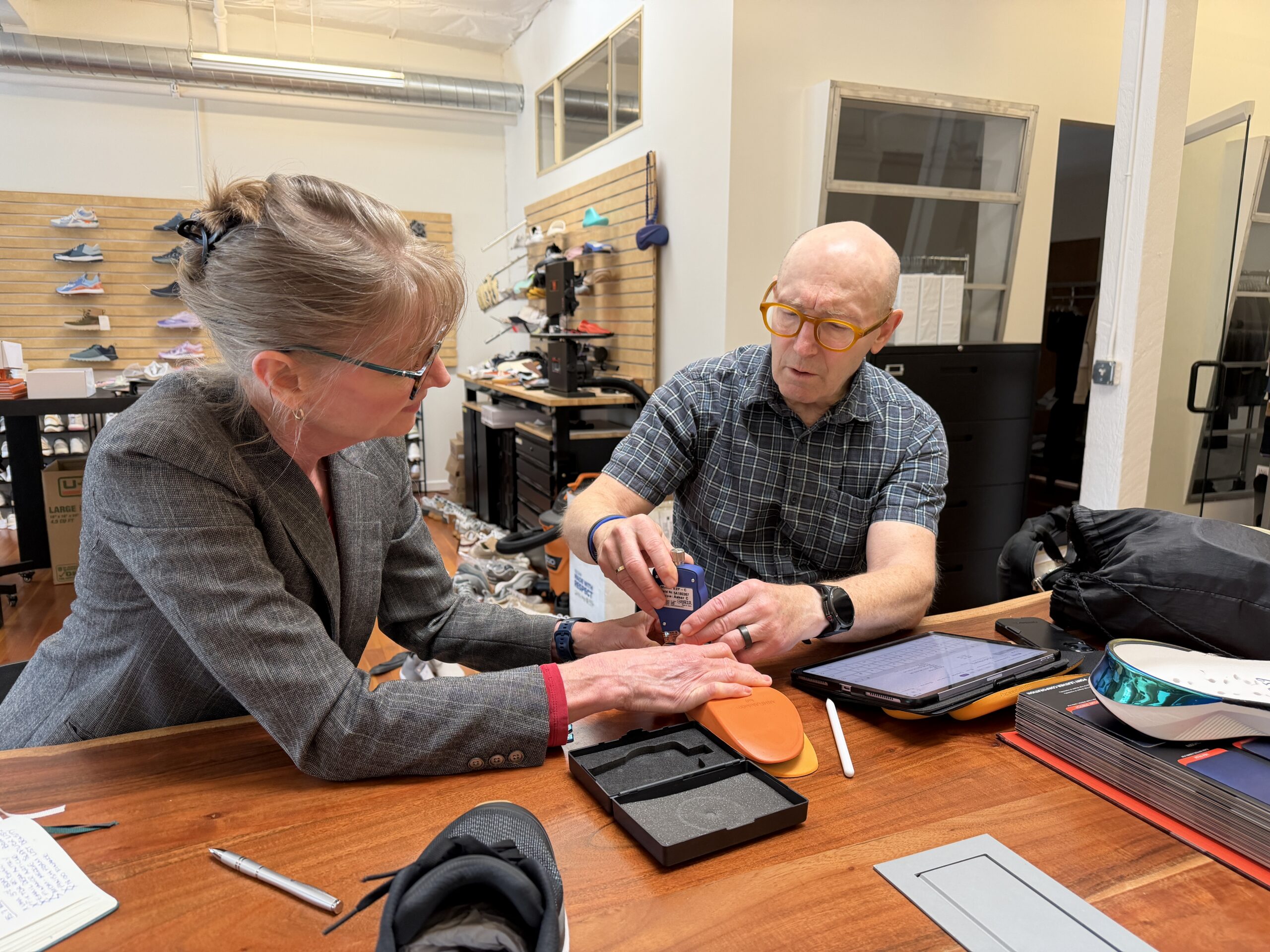 Two people utilizing ASTM hardness testing for a foam insole.