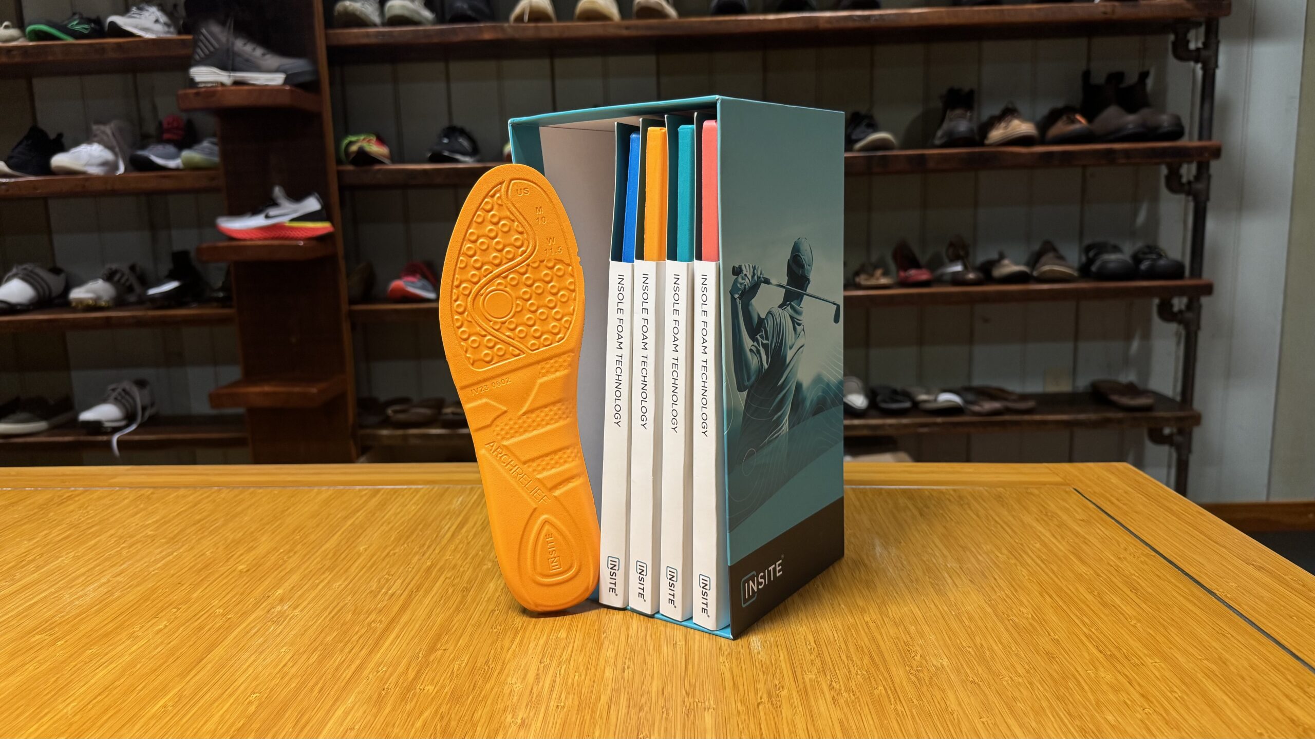 The INSITE footwear foams catalog box standing next to an orange INSITE ArchRelief insole