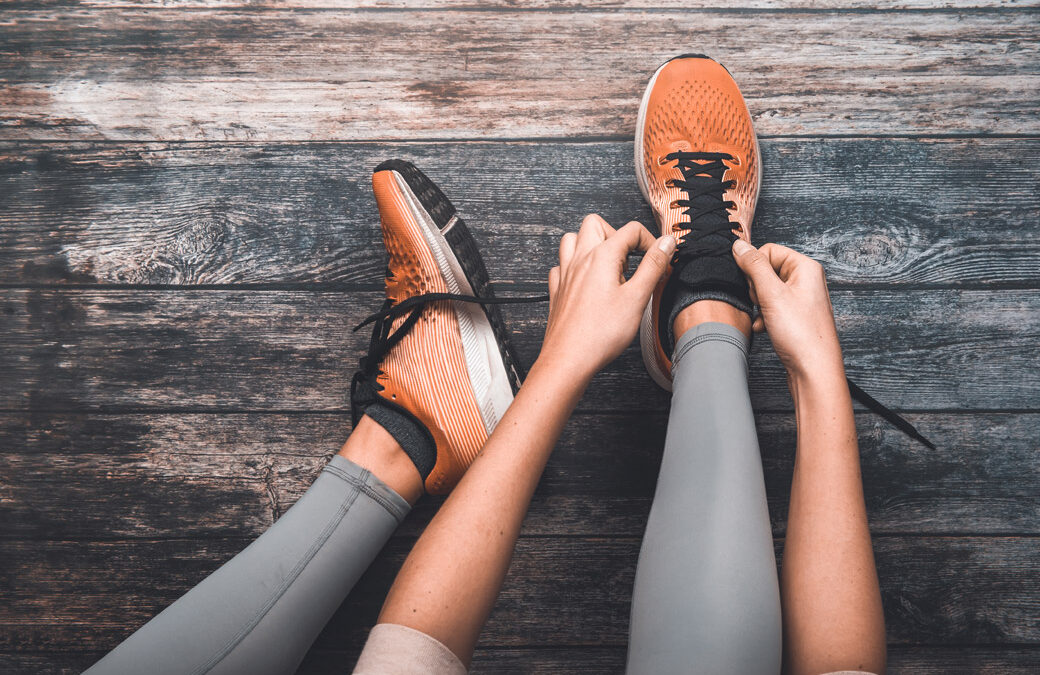 person lacing up athletic shoes