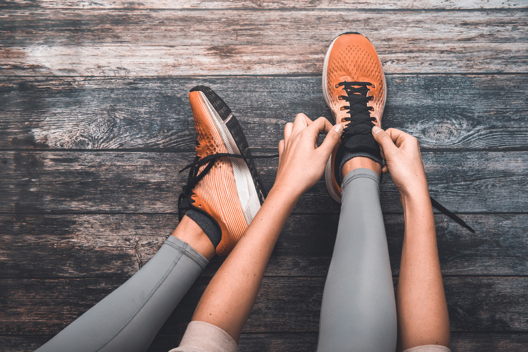 person lacing up athletic shoes
